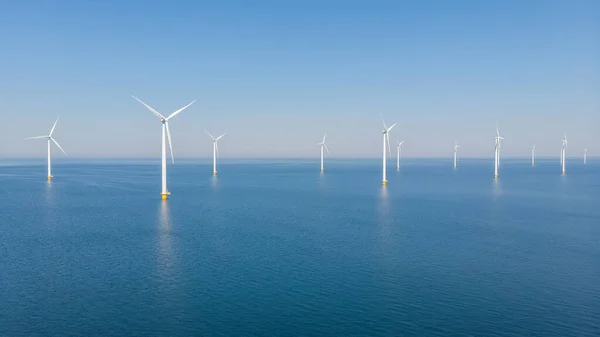 Windmill turbines at sea generate green energy in the Netherlands. Drone view at windmill park in the ocean