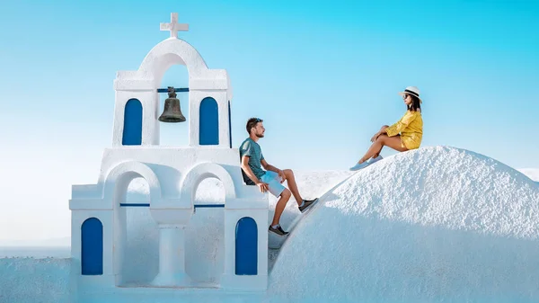 一对夫妇在希腊度蜜月参观Oia Santorini 男人和女孩在希腊度假与希腊教堂一起去了一个粉刷过的村庄 — 图库照片