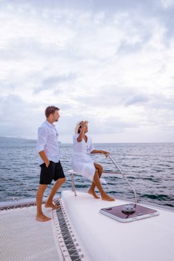 Aziz Lucia, birkaç erkek ve kadın yaz tatilinde Saint Lucia ya da St. Lucia Karayipleri yakınlarındaki Karayip denizinde gün batımını seyrediyorlar.