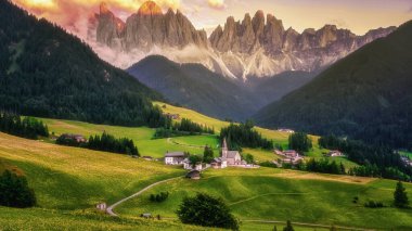 Val di Funes 'deki Santa Magdalena köyü İtalyan Dolomitleri üzerinde. Arkasında renkli ağaçlar ve Odle Dağı grubu olan vadinin sonbahar manzarası. İtalya Avrupa