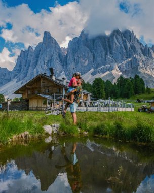 Geisler Alm, Dolomites Italya, Val Di Funes dağlarında yürüyüş yapan çiftler İtalyan Dolomitlerinde Doğa Parkı Geisler-Puez ve Güney Tyrol 'da Geisler Alm. İtalyan erkek ve kadın dağlarda yürüyorlar.