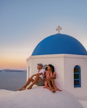 Santorini Yunanistan 'da tatilde olan bir çift, iki erkek ve kadın Oia Santorini' yi boyalı binalarla ziyaret ediyor. Santorini Yunanistan 'da