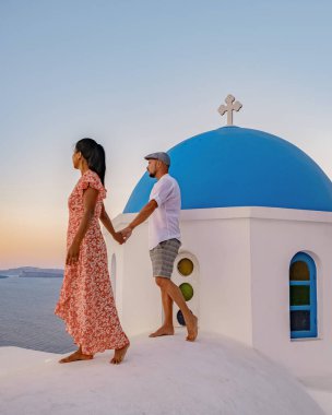 Santorini Yunanistan 'da tatilde olan bir çift, iki erkek ve kadın Oia Santorini' yi boyalı binalarla ziyaret ediyor. Santorini Yunanistan 'da