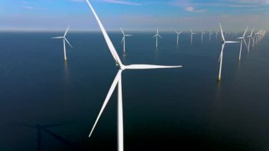 Bulutlu ve mavi gökyüzü olan yel değirmeni parkı, okyanus havası manzaralı rüzgar türbini Flevoland Hollanda Ijsselmeer