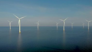 Bulutlu yel değirmeni türbinleri, mavi gökyüzü, okyanus havası manzaralı rüzgar türbini Flevoland Hollanda Ijsselmeer ile yel değirmeni parkı.