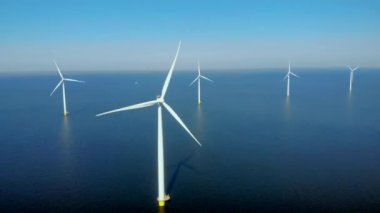 Bulutlu yel değirmeni türbinleri, mavi gökyüzü, okyanus havası manzaralı rüzgar türbini Flevoland Hollanda Ijsselmeer ile yel değirmeni parkı.
