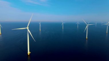 Bulutlu ve mavi gökyüzü olan yel değirmeni parkı, okyanus havası manzaralı rüzgar türbini Flevoland Hollanda Ijsselmeer