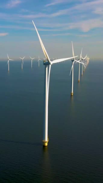 風車のドローンビュー 青い空の風車公園 風力タービンで海の空中ビューの風車公園 FlevolandオランダIjsselmeer — ストック動画