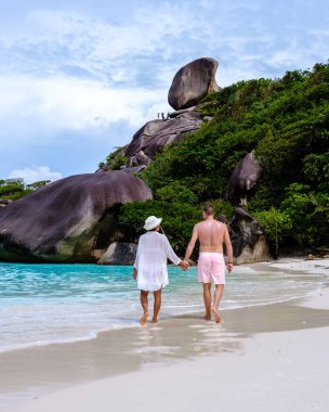 Güney Tayland 'daki tropik Similan Adaları' nda sahilde yürüyen bir çift. Erkekler ve kadınlar Similan sahilinde.