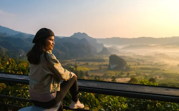 women watching the Sunrise with fog and mist at Phu Langka mountains in Northern Thailand, Mountain View of Phu Langka National Park at Phayao Province