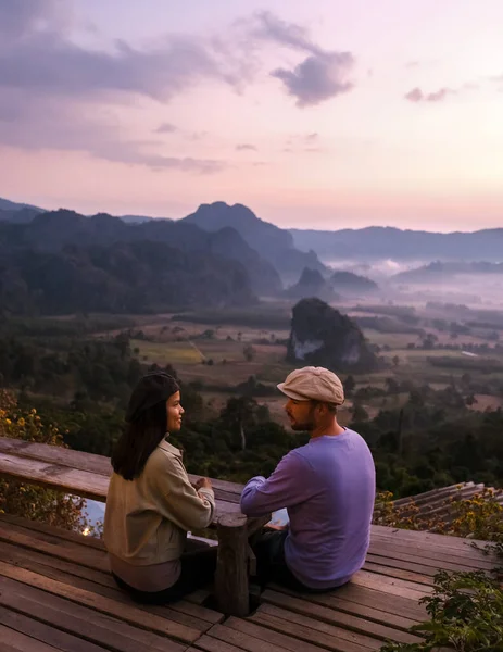 couple of men and women watching the Sunrise with fog and mist at Phu Langka mountains in Northern Thailand, Mountain View of Phu Langka National Park at Phayao Province