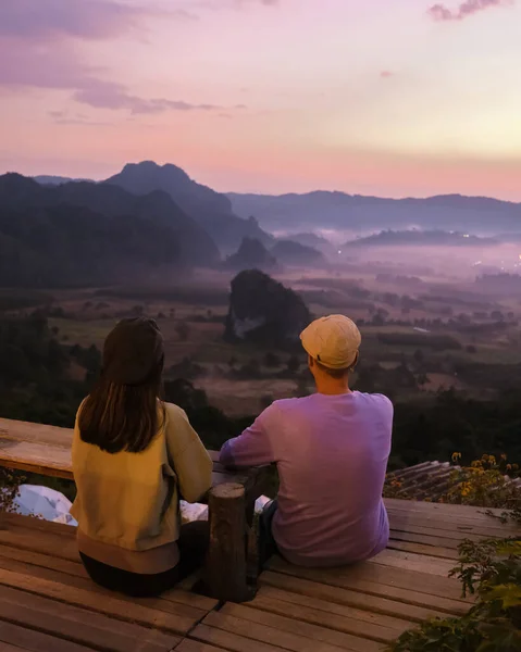 a couple of men and women watching the Sunrise with fog and mist at Phu Langka mountains in Northern Thailand, Mountain View of Phu Langka National Park at Phayao Province