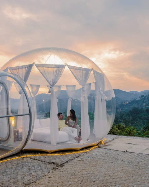 A couple of men and women staying at a luxury glamping tent in the mountains