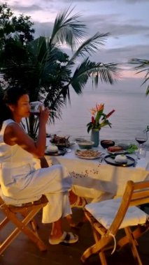 Asian Thai women having a Romantic dinner on the beach of Koh Chang in Thailand during sunset