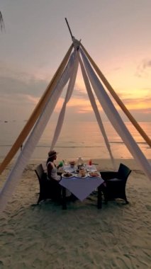 Asian Thai women having a Romantic dinner on the beach of Koh Chang in Thailand during sunset