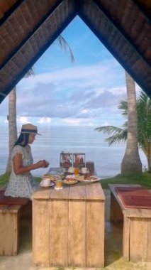 Asian women having breakfast on the beach of Koh Mak Thailand. 