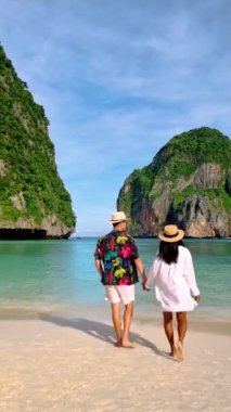 Couple men and women walking at the beach of Maya bay at the Tropical Island of Koh Phi Phi Thailand, couple on vacation in Thailand