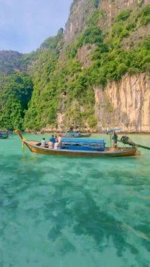 Longtail boats and green blue turqouse lagoon at Pileh Lagoon Tropical Island of Koh Phi Phi Thailand