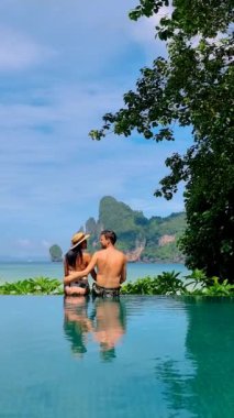 Couple at an infinity pool in Koh Phi Phi Thailand, men and women relaxing at the pool.