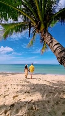 couple on a tropical beach during vacation at the Island of Koh Kood in Thailand, men and women on a white beach 