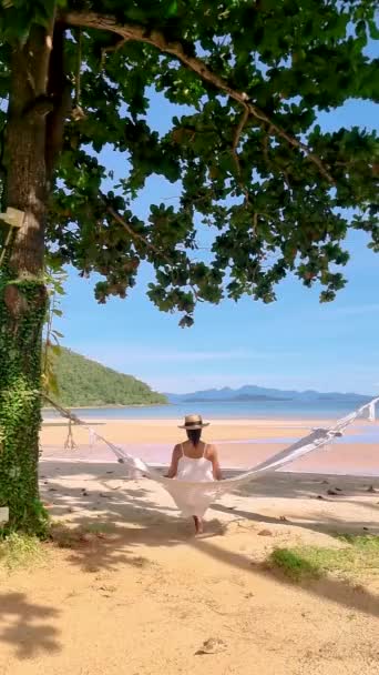休暇中にタイのコ マック島のビーチでハンモックで男と女のカップル — ストック動画