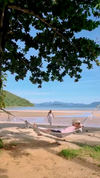 休暇中にタイのコ マック島のビーチでハンモックで男と女のカップル — ストック動画