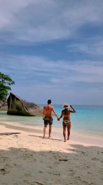 A couple of men and Asian women relaxing on the beach of the Tropical Island Similan in Southern Thailand. 
