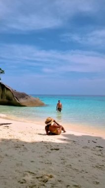 Couple relaxing on the beach of the Tropical Island Similan in Southern Thailand. 