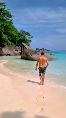 Young men in swimshort on the beach of the Tropical Island Similan in Southern Thailand