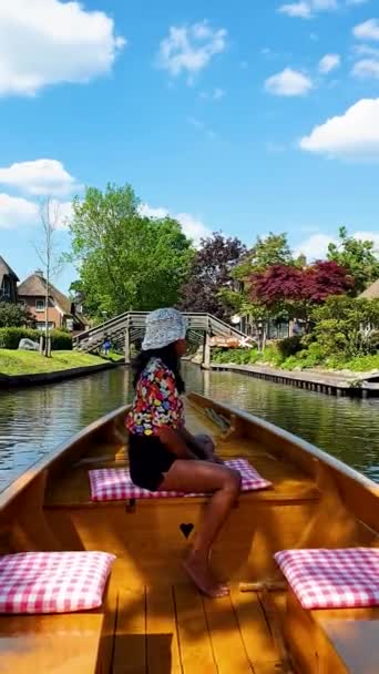 オランダの村の運河にある木製のボートでアジアの女性 Giethoorn Ortherland — ストック動画