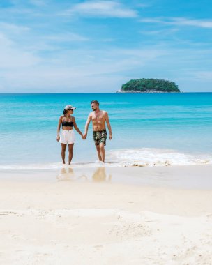 Tatil sırasında Kata Phuket Tayland sahilinde yürüyen bir çift.