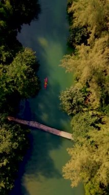a couple of men and women in a kayak in the lagoon rainforest of Koh Chang Island Thailand.