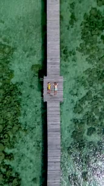 一对穿着泳衣的男女情侣躺在泰国热带岛屿的一个木制码头上 泰国Koh Kham Koh Mak岛一个木制防波堤上的男男女女 — 图库视频影像