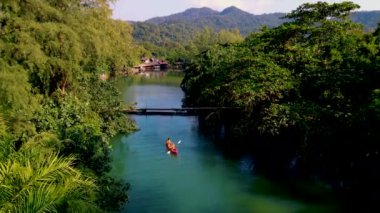 a couple of men and women in a kayak in the lagoon rainforest of Koh Chang Island Thailand.