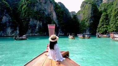 Asian Thai women in front of a longtail boat at Koh Phi Phi Island Thailand, Pileh Lagoon.