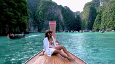 Asian Thai women in front of a longtail boat at Koh Phi Phi Island Thailand, Pileh Lagoon.