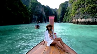 Asian women in front of a longtail boat at Koh Phi Phi Island Thailand,