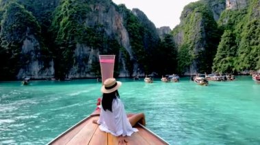 Asian Thai women in front of a longtail boat at Koh Phi Phi Island Thailand, Pileh Lagoon.