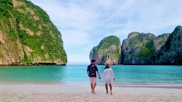 ピピ島の石灰岩の崖がある熱帯の白いビーチでカップルタイ 男性と女性はビーチを歩く — ストック動画