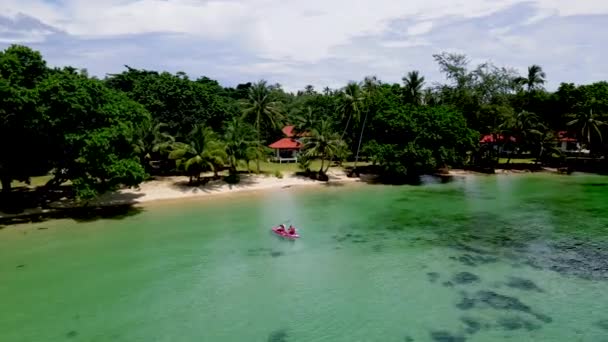 タイの熱帯の島カヤックのカップル コマックの緑の青いタークス色の海 休暇中のカヤックの男性と女性無人航空機の眺め — ストック動画