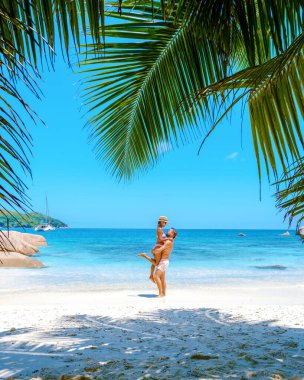 Praslin Seychelles tropical island with white beaches and palm trees, a couple of men and women mid age on vacation at Seychelles visiting the tropical beach Anse Lazio Praslin Seychelles