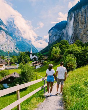Lauterbrunnen valley,village Lauterbrunnen, Staubbach Fall, and Lauterbrunnen Wall in the Swiss Alps, Switzerland. Europe Lauterbrunnen valley, a couple of Caucasian men and Asian women on vacation