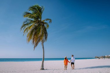 Kartal Sahili Aruba, Aruba 'daki Kartal Sahili' nin kıyısında Palmiye Ağaçları, Aruba sahilinde çift erkek ve kadın.