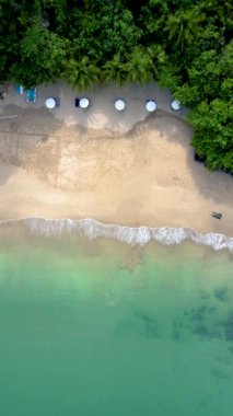 Drone view from above at the ocean and tropical beach with umbrella at the Island of Koh Lanta Thailand. 