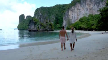 couple of men and women on a tropical white beach in Thailand, Koh Hong Island Krabi during summer vacation in Thailand