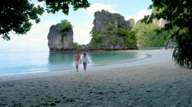 couple of men and women on a tropical white beach in Thailand, Koh Hong Island Krabi during summer vacation in Thailand