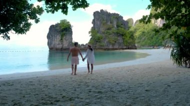 couple of caucasian men and Asian women on a tropical white beach in Thailand, Koh Hong Island Krabi during summer vacation in Thailand