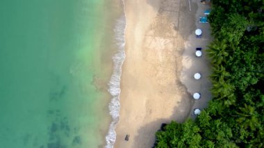 Drone view from above at the ocean and tropical beach with umbrella at the Island of Koh Lanta Thailand. 