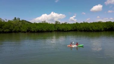 couple in a kayak at the mangrove forest in Phuket Thailand. men and women paddling in a kayak during vacation