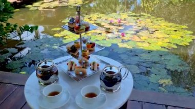 Bir su birikintisinde ikindi çayı, Tayland 'da tropikal bir bahçede çay.